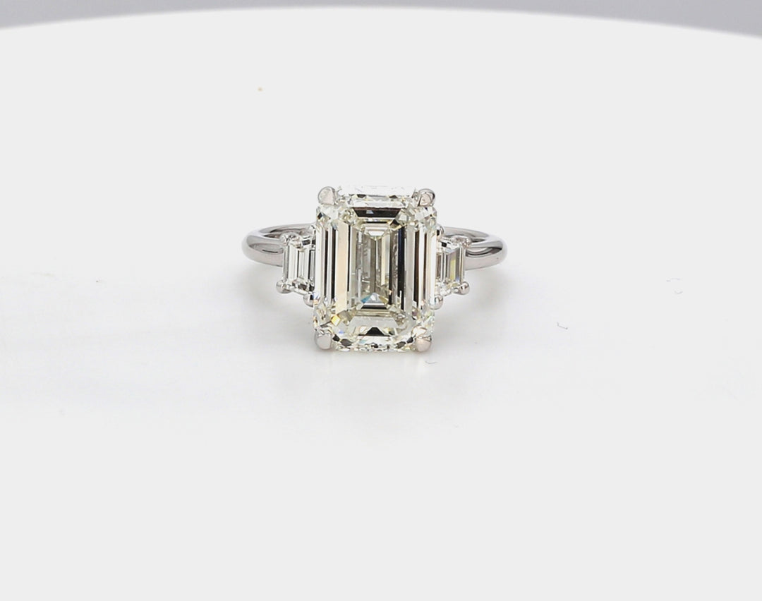 3-stone ring in platinum with basket prong set GIA certified J/VS2 emerald cut center and step cut trapezoid diamond sides.  D6.61ct.t.w.  (Center - 6.18ct.)