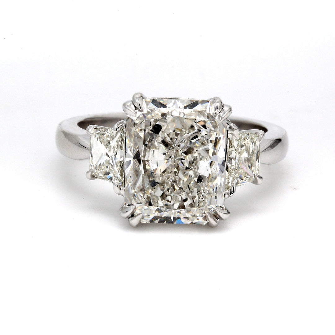 3-stone ring in platinum with eagle claw set GIA certified I/SI2 radiant center and brilliant cut trapezoid diamond sides.  D5.85ct.t.w.  (Center 5.01ct.)  Size 6.75