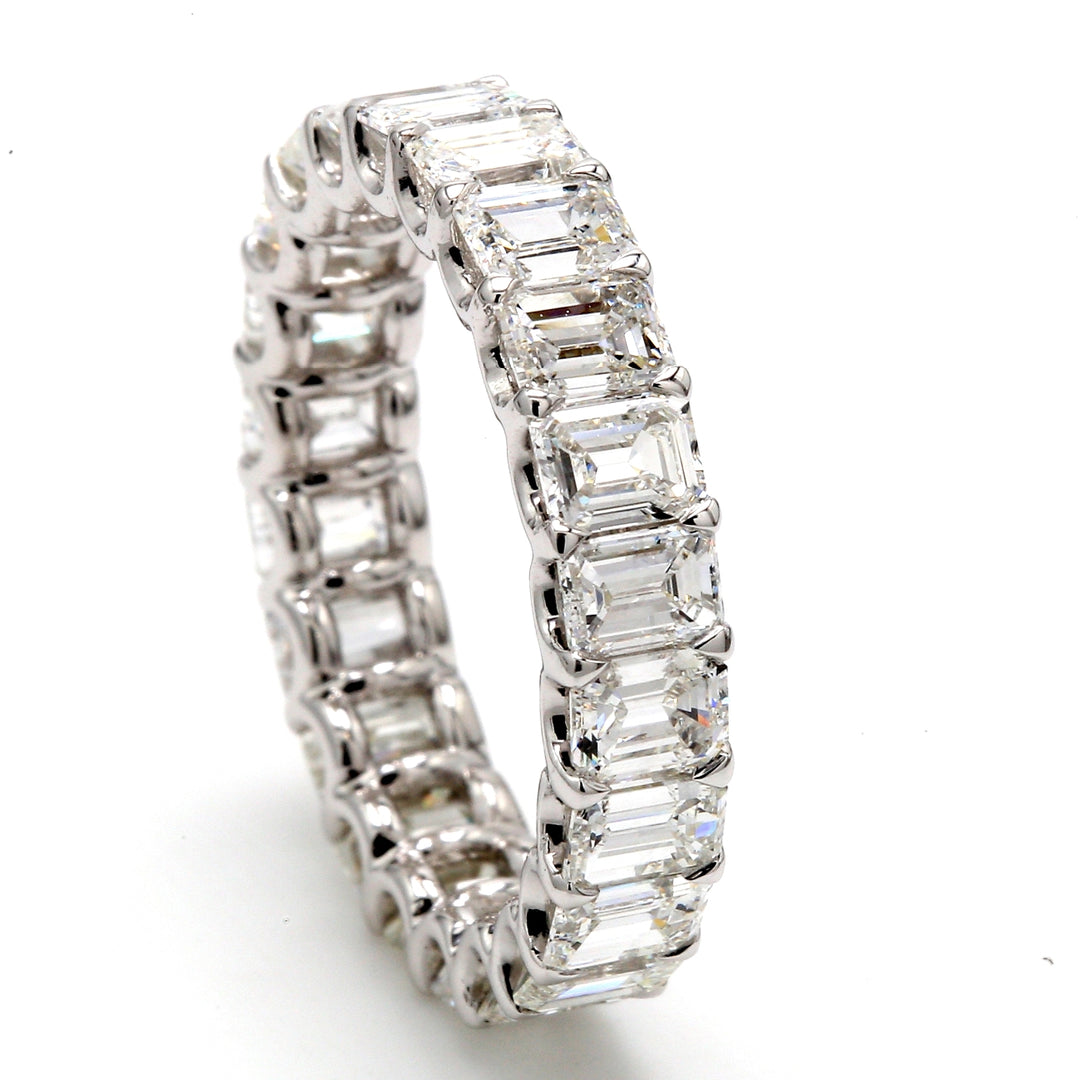 Eternity band in platinum with shared U-prong set F-G/VS (22) emerald cut diamonds.  D4.53ct.t.w.  Size 6