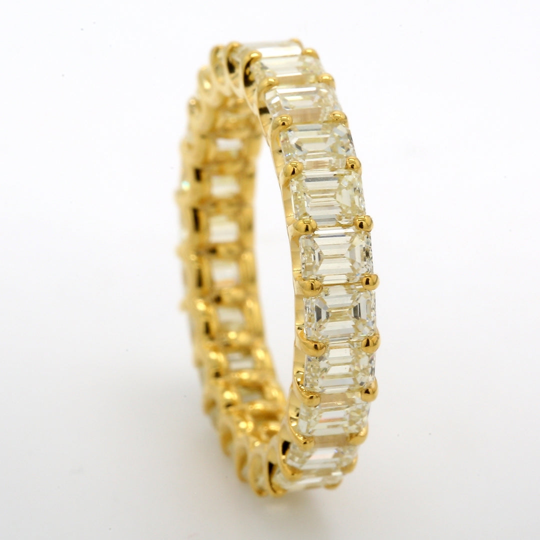 Eternity band in 18K YG with shared U-prong set FY/VS (23) emerald cut diamonds.  D4.55ct.t.w.  Size 6