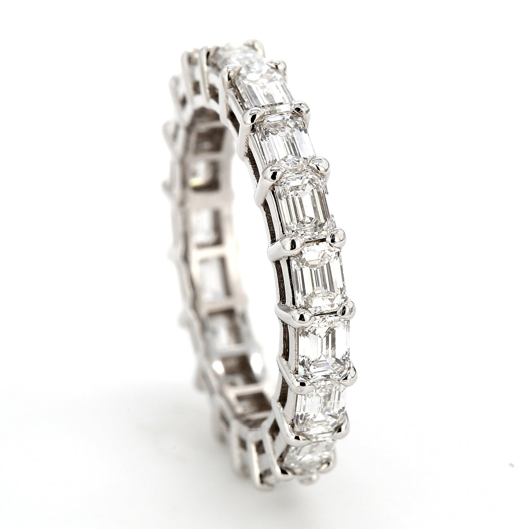 Eternity band east to west style in platinum with shared prong set (19) emerald cut diamonds.  D2.80ct.t.w.  Size 6