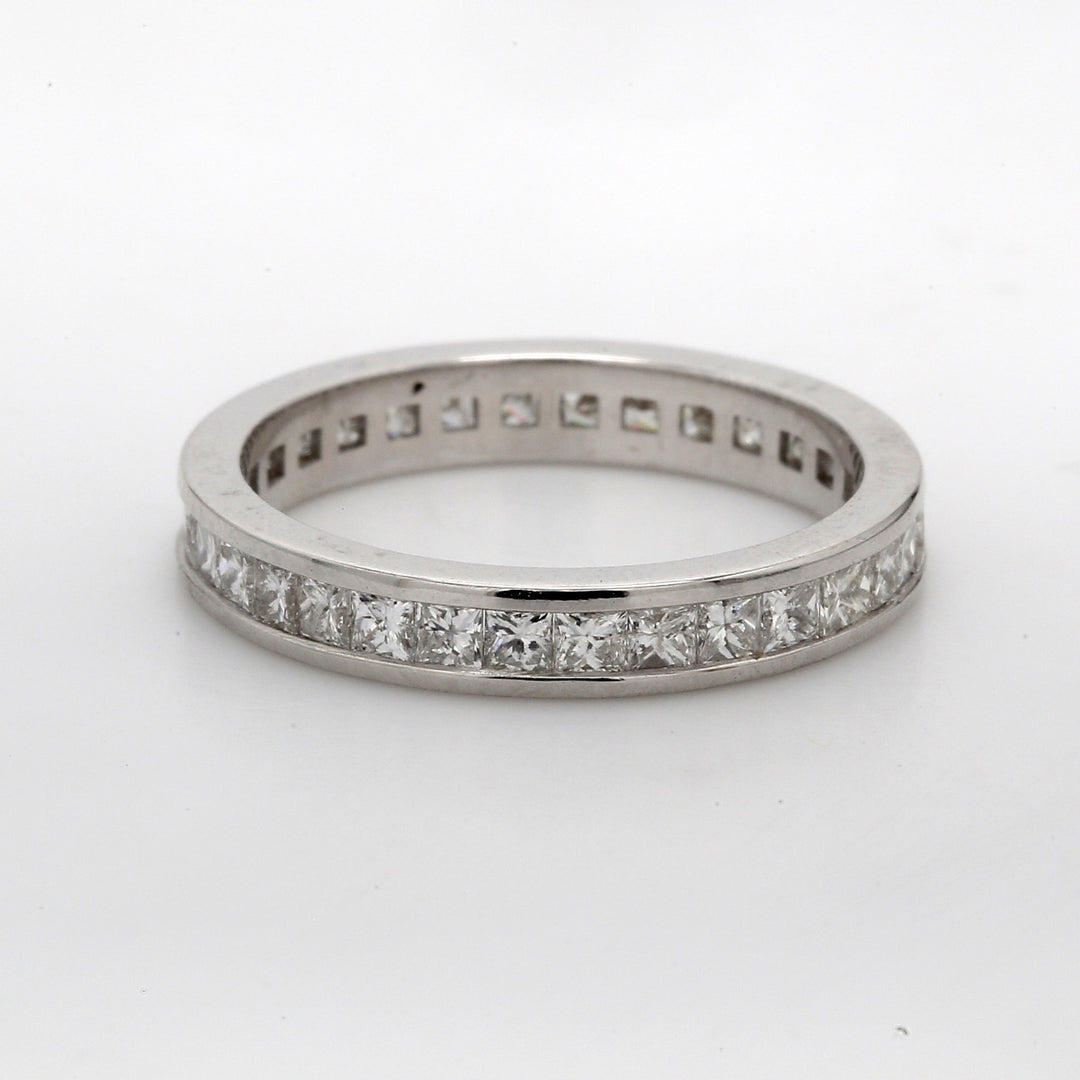 Eternity band in white gold with channel set (32) princess cut diamonds.  D1.21ct.t.w.  Size 5.5