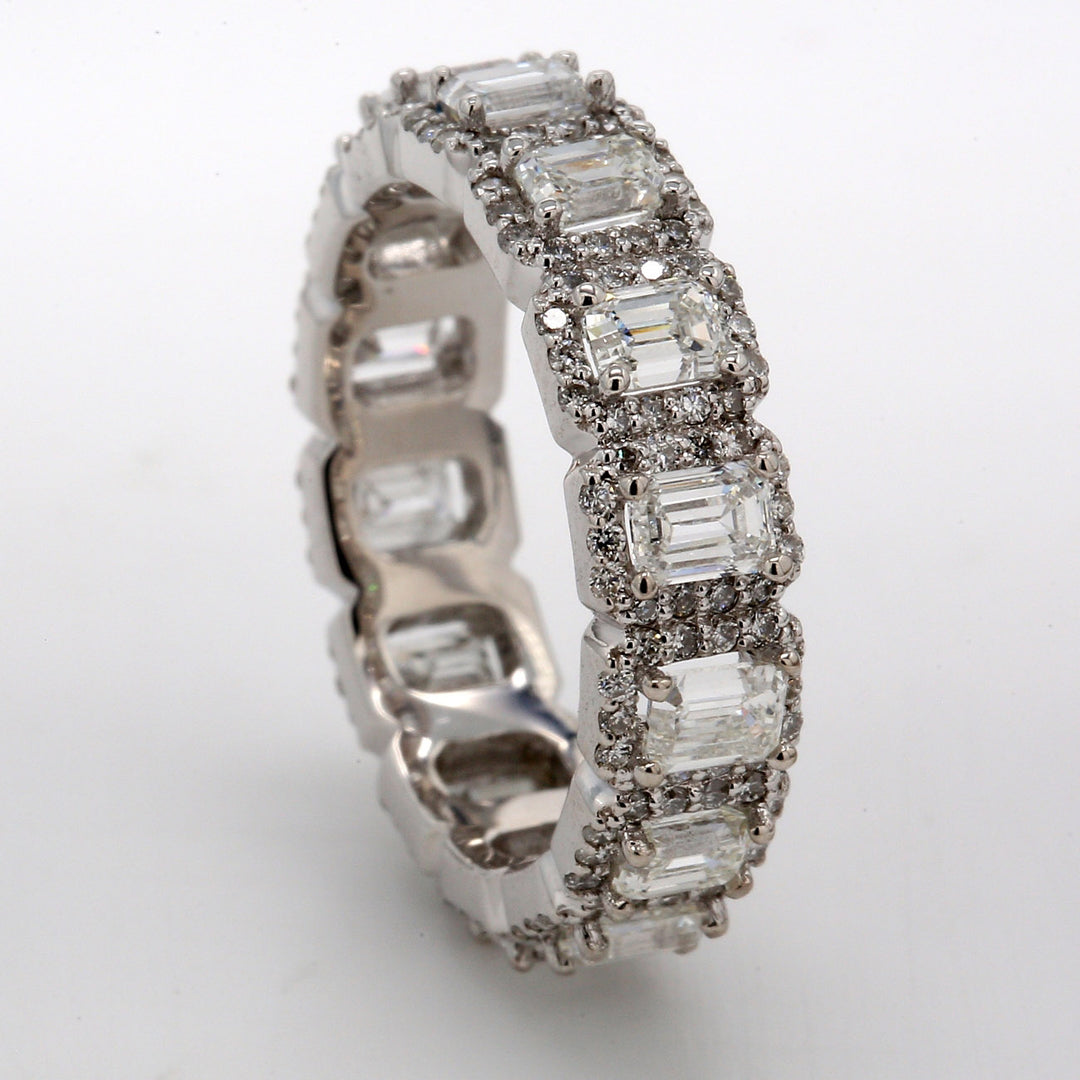 Halo eternity band in 18K WG with prong set (14)emerald cut centers & round diamonds.  D3.28ct.t.w.  Size 6.25