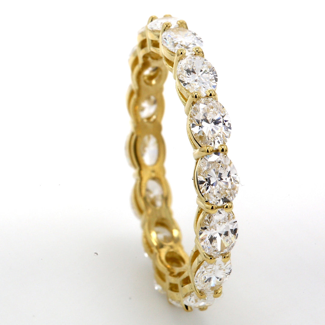 East to west style eternity band in 18K YG with basket prong set (16) oval diamonds.  D2.16ct.t.w.  Size 6.5