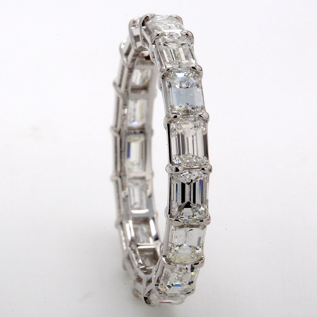 East to west style eternity band in 18K WG with basket set (17) emerald cut diamonds.  D3.14ct.t.w.  Size 6.5