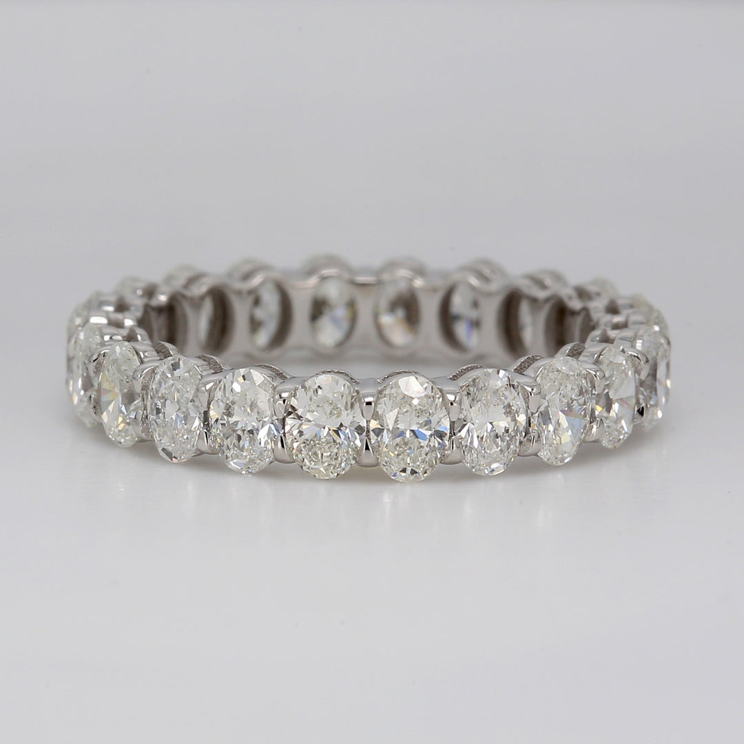 Eternity band in platinum with shared basket claw prong set (18) oval cut diamonds.  D5.42ct.t.w.  Size 6
