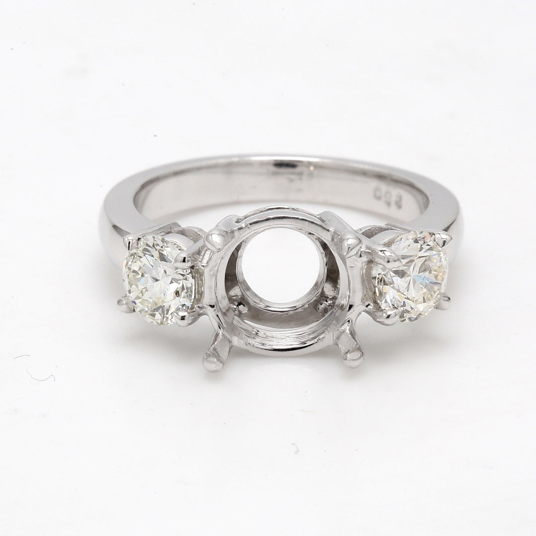 3-stone ring in platinum with prong set round sides and USA certified J/SI2 round diamond center.  D6.06ct.t.w.