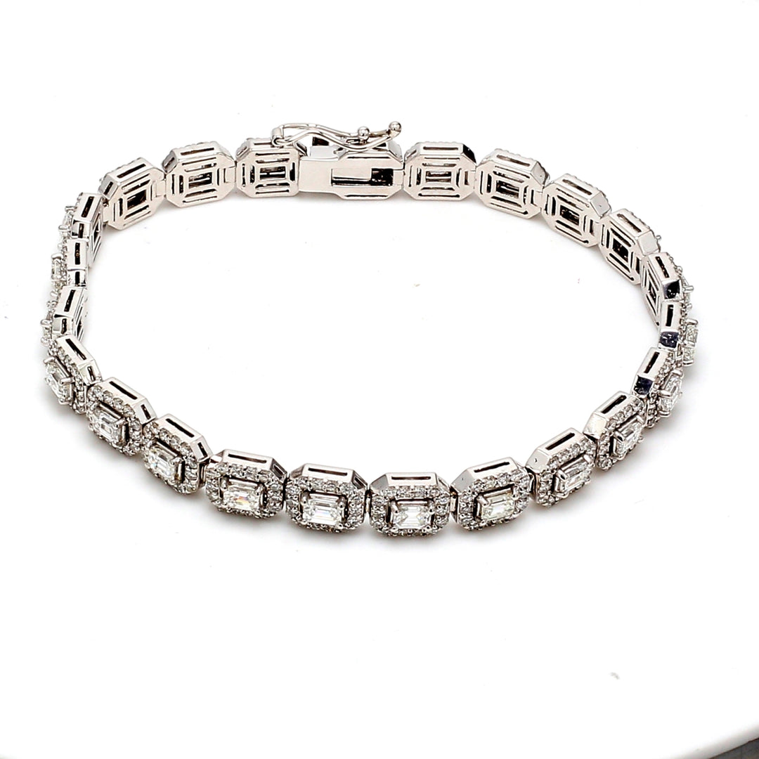 7"" Halo tennis bracelet with prong set rounds around emerald cut diamond center stones.  D6.84ct.t.w.