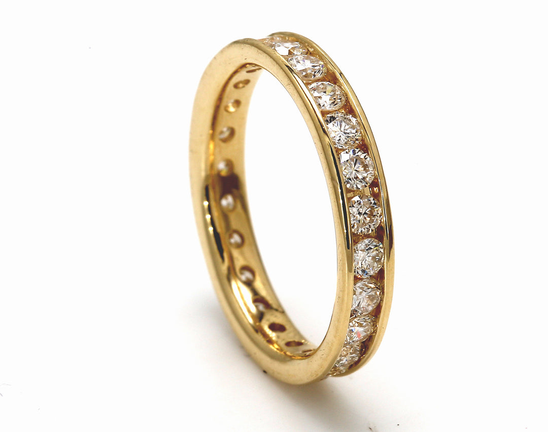 Eternity band in yellow gold with channel set round diamonds.  D0.97ct.t.w.  Size 4.5