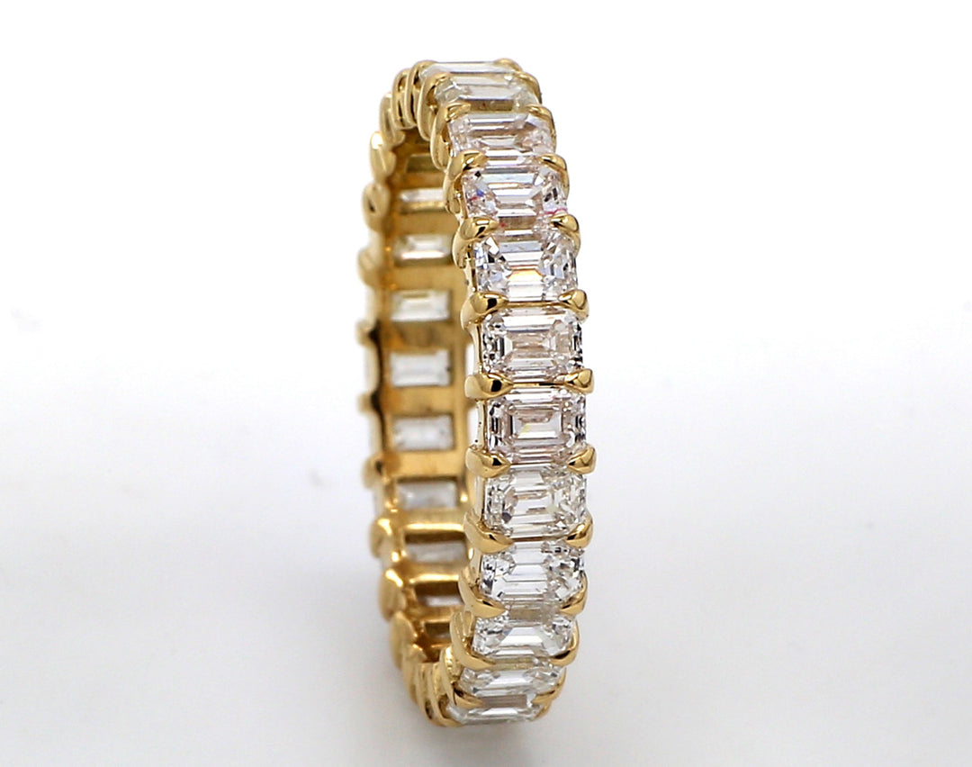 Eternity band in 18K YG with basket prong set (26) emerald cut diamonds.  D3.60ct.t.w.  Size 7
