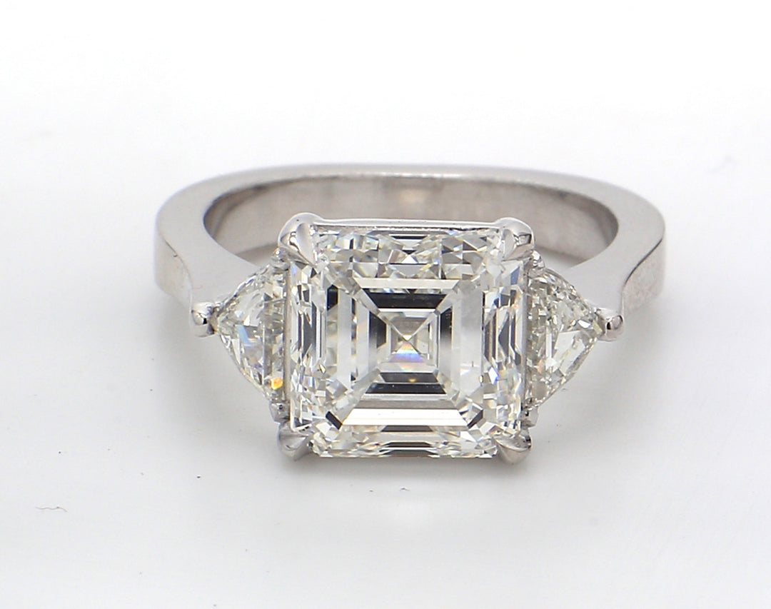 3-stone ring in platinum with prong set GIA certified G/VS2 asscher cut center and triangular diamond side stones.  D5.78ct.t.w.  (Center 5.07ct.)  Size 6.25