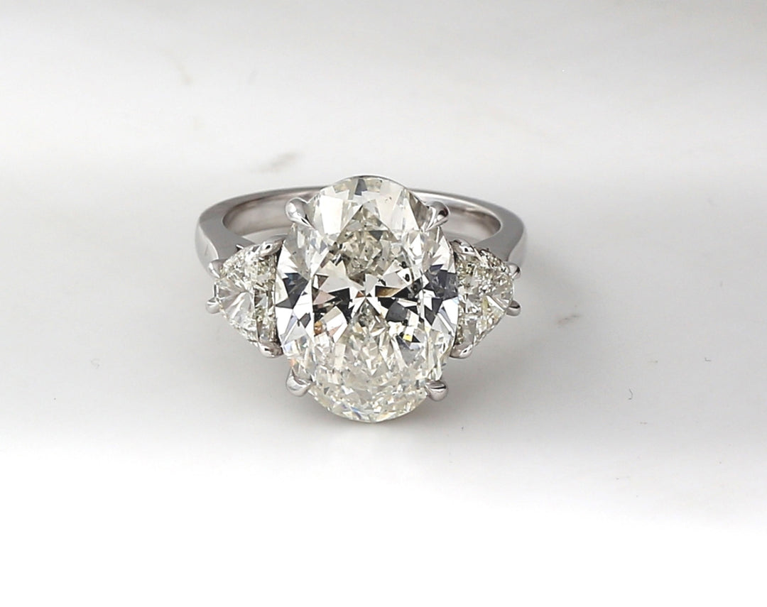 3-stone ring in platinum with GIA certified I/SI2 oval center and half moon diamond sides.  D8.04ct.t.w. (Center - 7.01ct.)