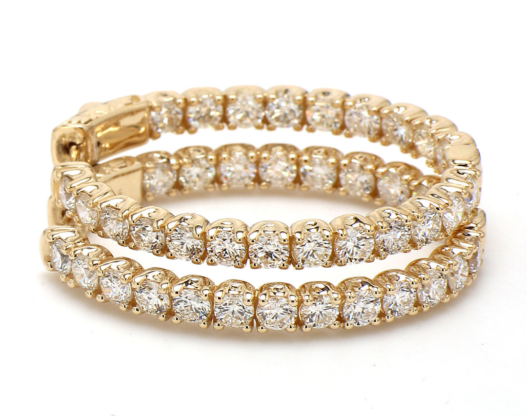 1.25"" Oval shaped inside out hoop earrings in yellow gold with prong set round diamonds.  D4.77ct.t.w.