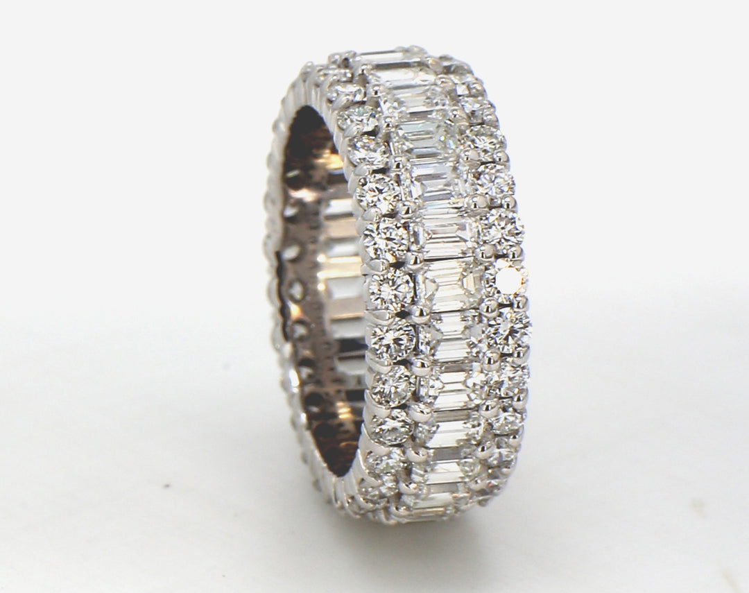 Eternity band in 18K WG with combination prong set emeralds and round diamonds.  D4.30ct.t.w.  Size 4.75