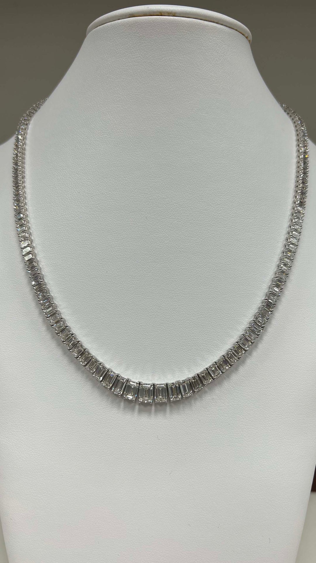 17"" Graduating tennis necklace in platinum with prong set (151) emerald cut diamonds.  D27.70ct.t.w.  (Center - 1.00ct.)