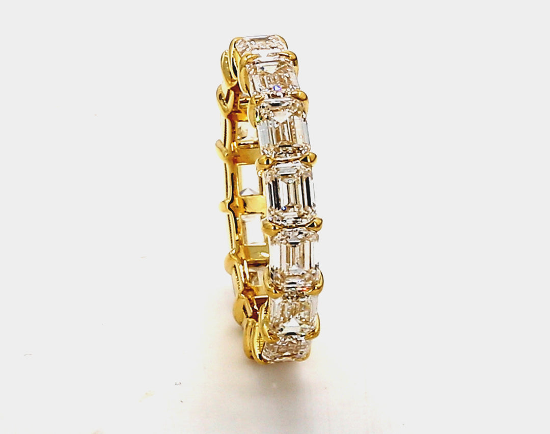 Eternity band east to west style in 18K YG with basket set (15) emerald cut diamonds.  D4.64ct.t.w.  Size 6