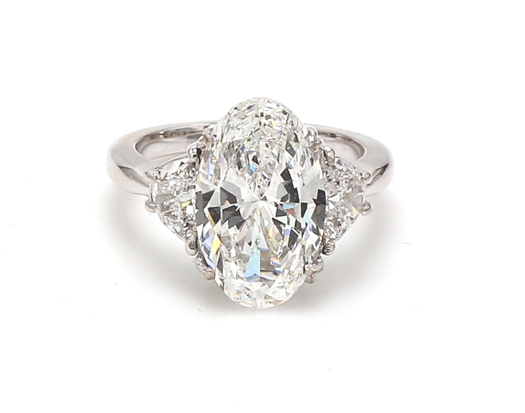 3-stone ring in 18K WG with GIA certified G/VS2 oval cut center and half moon diamond sides.  D6.01ct.t.w.  (Center - 5.01ct.)  Size 6.5