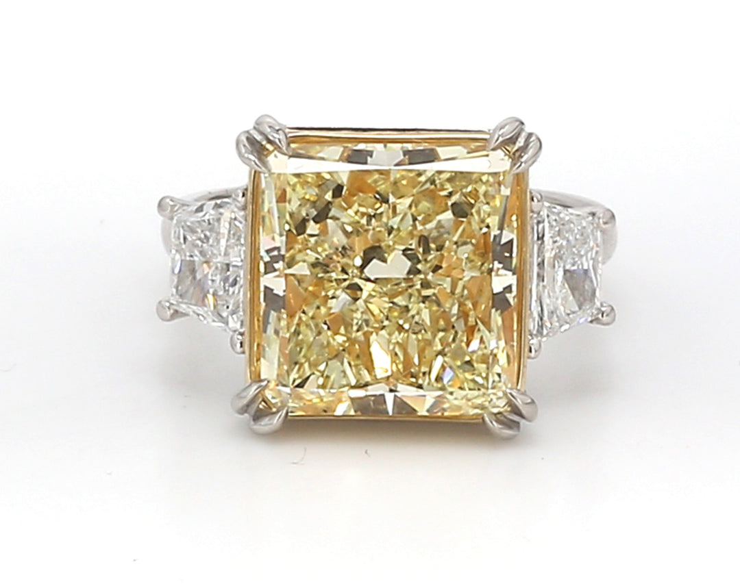 3-stone ring in platinum and 18K YG with prong set GIA certified FY/SI2 radiant cut center and prong set brilliant cut trapezoid diamond sides.  D7.87ct.t.w.  (Center - 7.03ct.)  Size 6